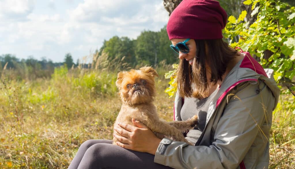woman sitting with brussels griffon